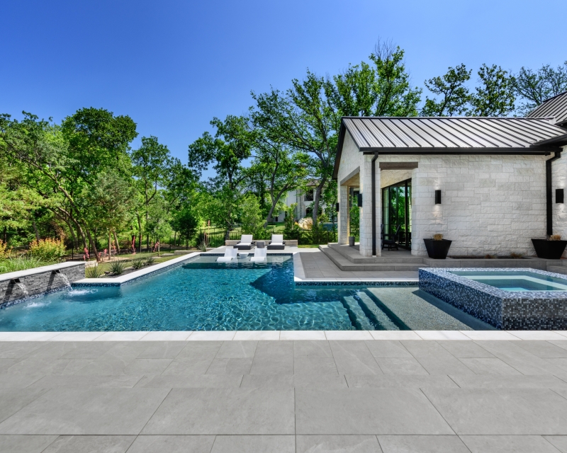 small backyard with geometric pool with integrated spa and pool features